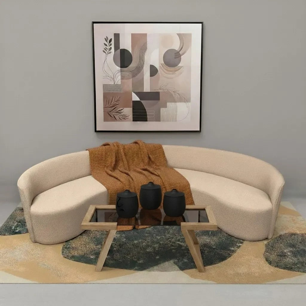 HANKI Luna curved crescent sofa in cream bouclé fabric with a textured orange throw blanket in a modern living room.