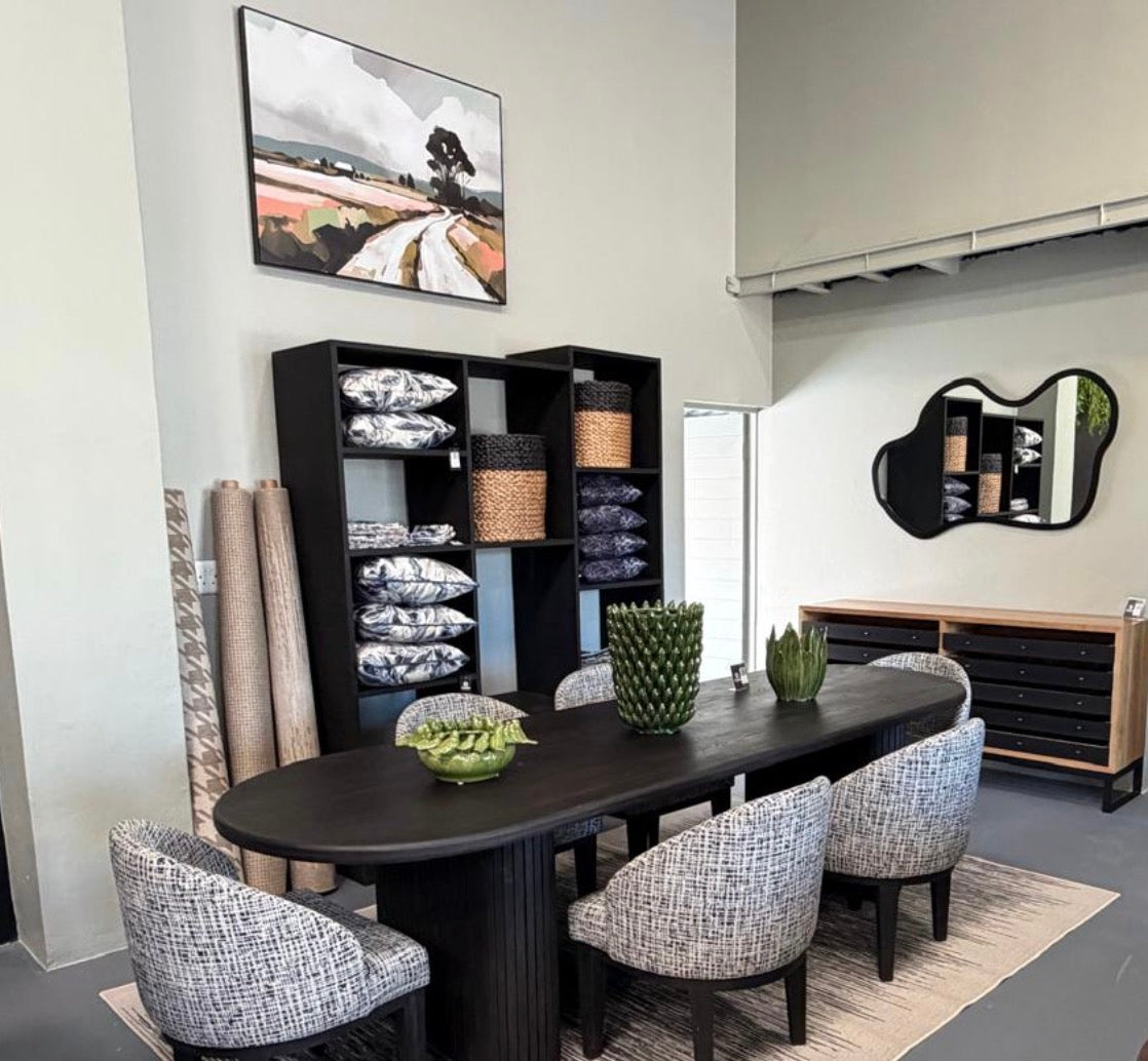 HANKI Elborn oval dining table styled in showroom with patterned dining chairs and decor